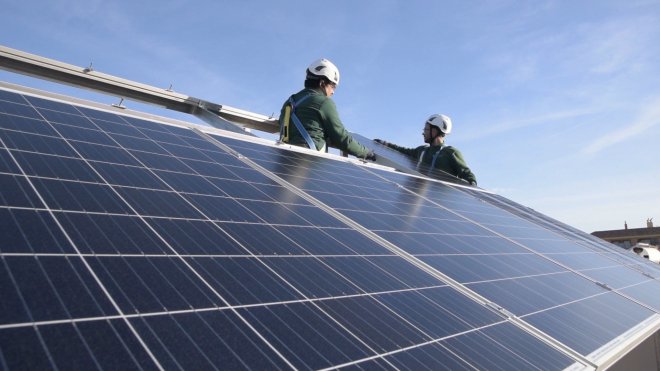 Unos trabajadores instalan paneles solares.